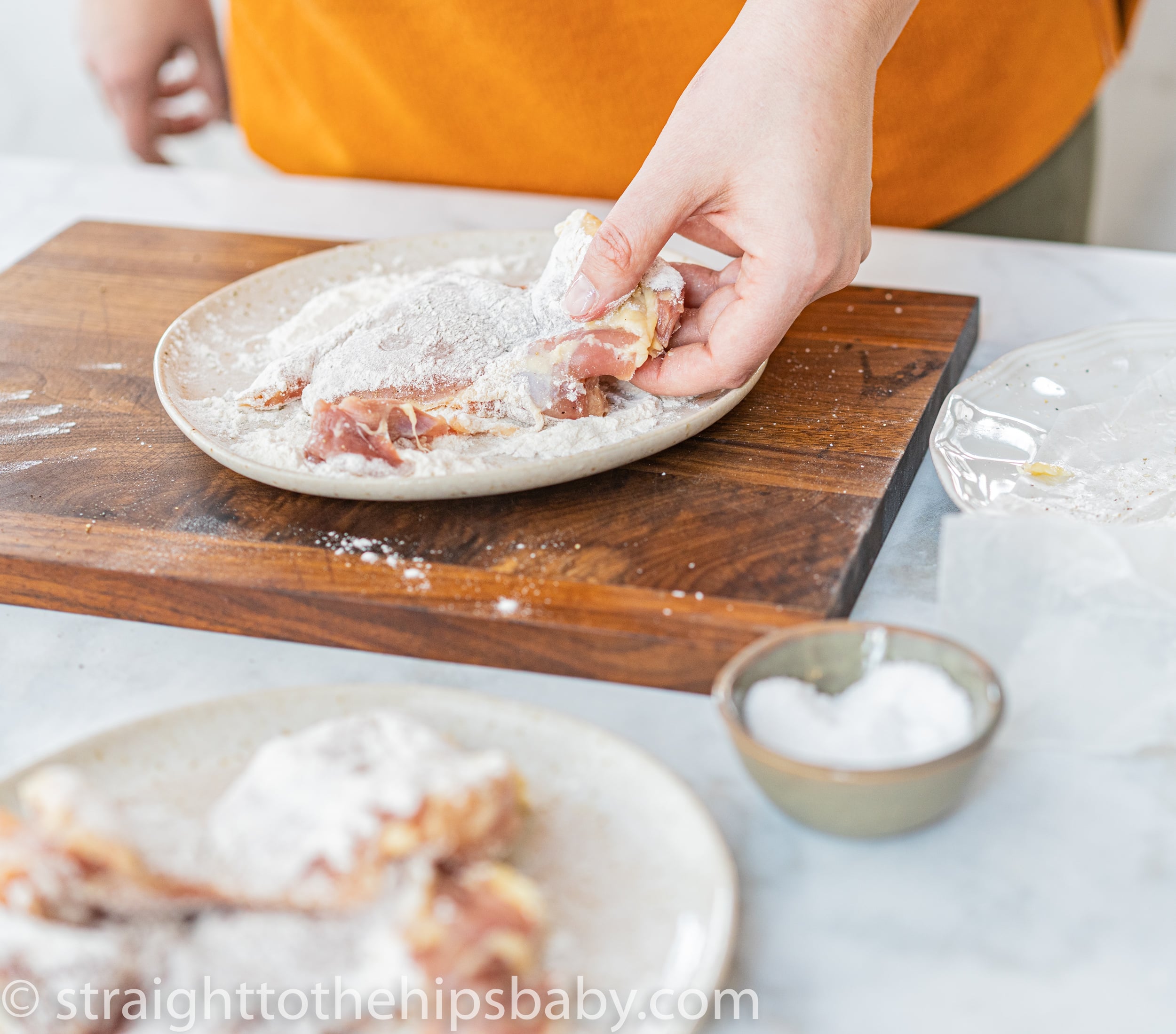 Dredging chicken thighs in seasoned flour before searing for paprikash