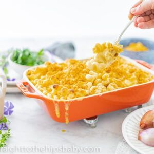 Creamy cheddar and Gruyère macaroni and cheese in a white baking dish with golden cornflake topping